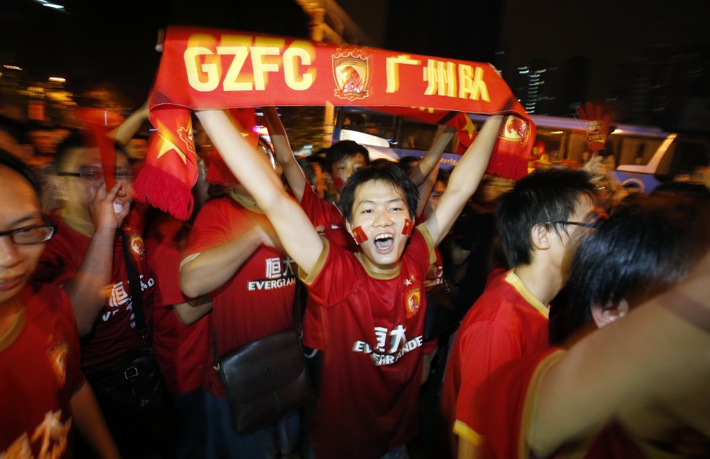 China's Guangzhou Evergrande fans celebrate after their team won the final match of the AFC Champions' League against South Korea's FC Seoul at Tianhe stadium in the southern Chinese city of Guangzhou, in this November 9, 2013 file photo. Alibaba Group Holding, China's largest e-commerce company, agreed on June 5, 2014 to take a 50 percent stake in Guangzhou Evergrande Football Club, winners of last year's Asian Champions League, for 1.2 billion yuan ($192 million). REUTERS/Bobby Yip/Files (CHINA - Tags: SPORT SOCCER BUSINESS)